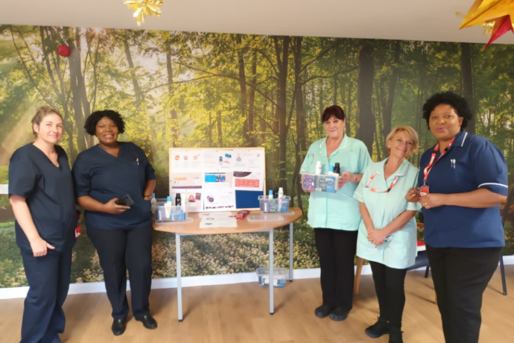 Team at Nottingham standing next to a wellbeing board.